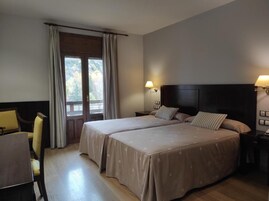 Una habitación de hotel con dos camas, un escritorio y una silla.