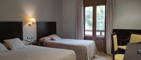 Ein Hotelzimmer mit zwei Betten, einem Schreibtisch und einem Stuhl.