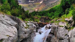 A mountainous landscape with a waterfall, rocky terrain, and lush greenery. - Snö Bielsa (Bielsa)