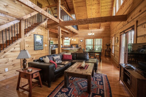 L’intérieur d’une cabane en rondins comprend un escalier, un salon, un coin repas et une cuisine.