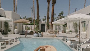 Una piscina al aire libre, camas de piscina gratis, sombrillas