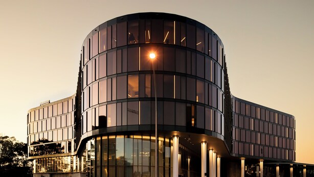 A modern building with a curved facade, large windows, and a visible 'Pullman' sign. - Pullman Sydney Penrith (Penrith)