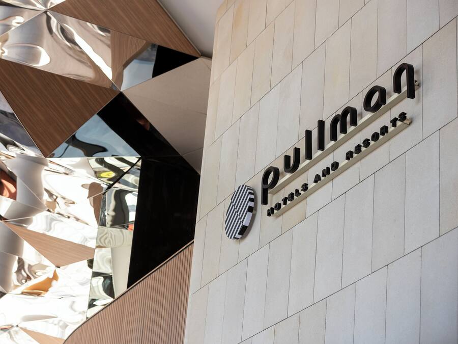A hotel sign with a geometric design and the name "Pullman" prominently displayed.