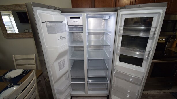 Eine Küche mit eingebautem Kühlschrank, Holzschränken und einem Essbereich mit Tisch und Stühlen.