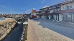 Un bâtiment situé sur la côte, doté d’une piscine, d’un patio couvert et offrant une vue sur la mer.