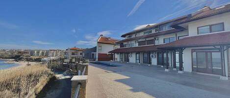Ein Küstengebäude mit Pool, überdachter Terrasse und Meerblick.