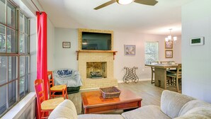 A living room with a fireplace, a dining area, and a ceiling fan. - Ole Miss Spirit Lives 2 Mi From Campus (Oxford)