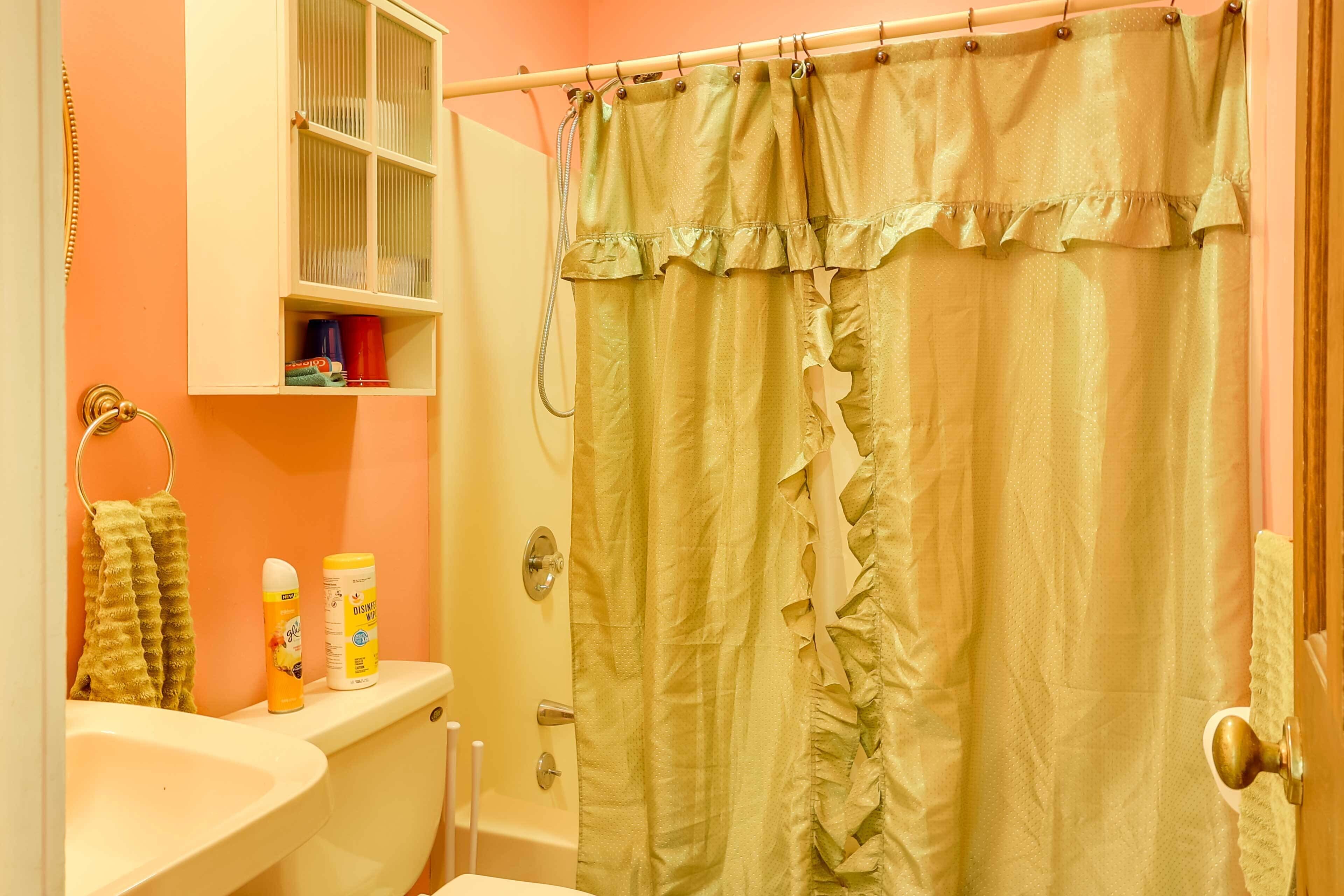 Un baño con inodoro, lavamanos y cortina de ducha.