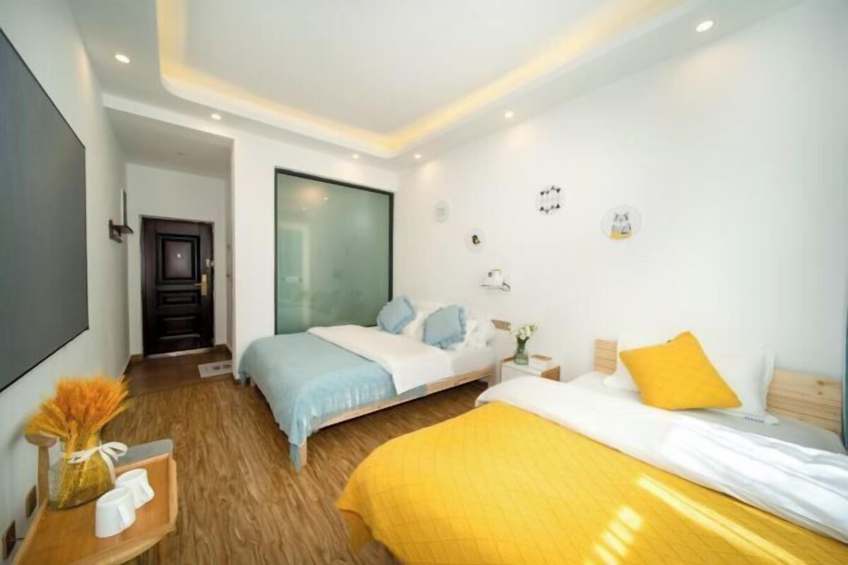 A modern hotel room with a bed, bedside table, and a large window.
