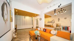 A modern living room with a wooden floor, a sofa set, and a dining area. - Private running bar post Dali ancient shop (Dali City)
