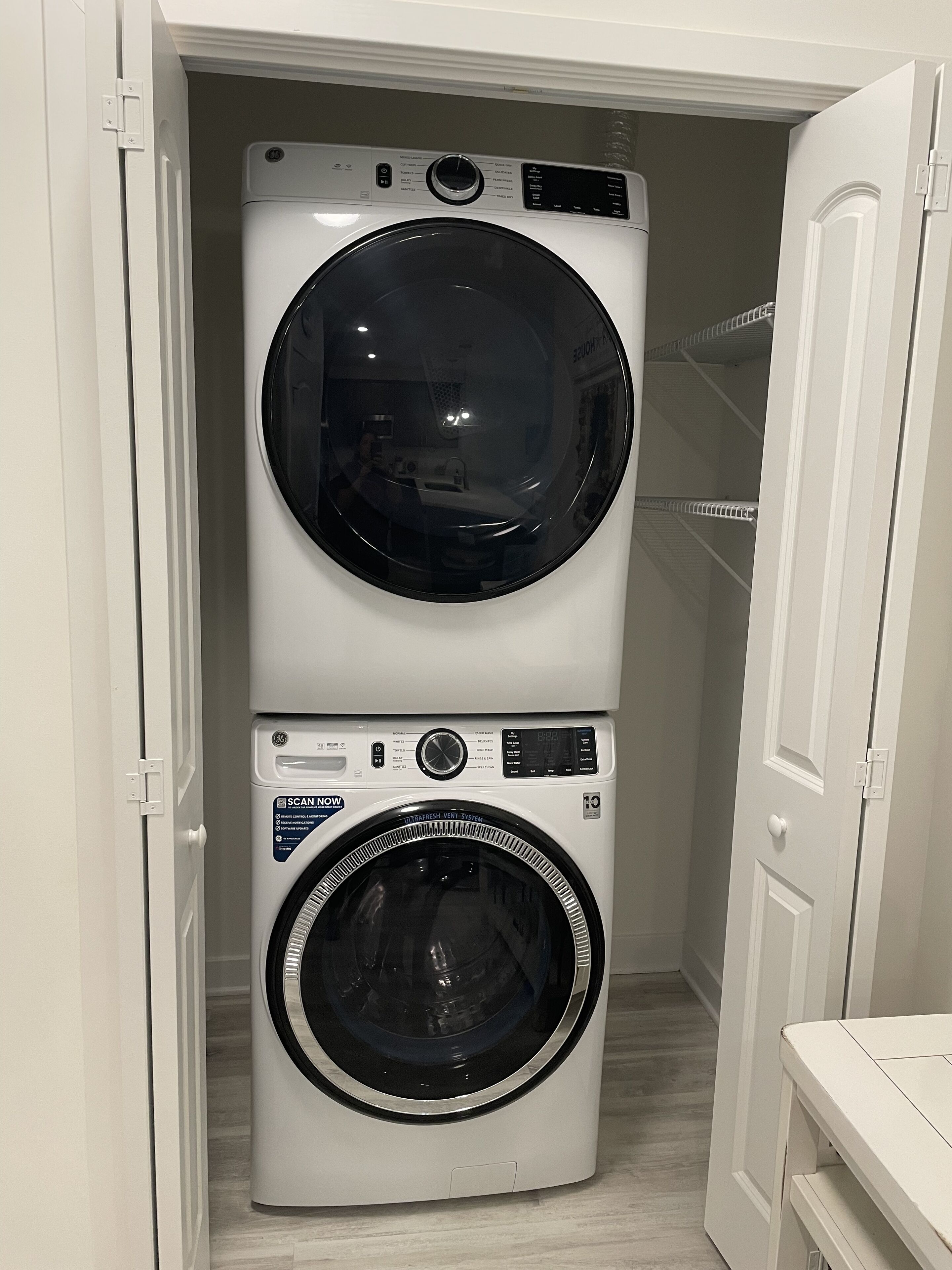 A compact laundry room with a stacked washer and dryer.