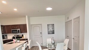 A modern kitchen with dark wood cabinets, a stainless steel microwave, and a coffee maker.
