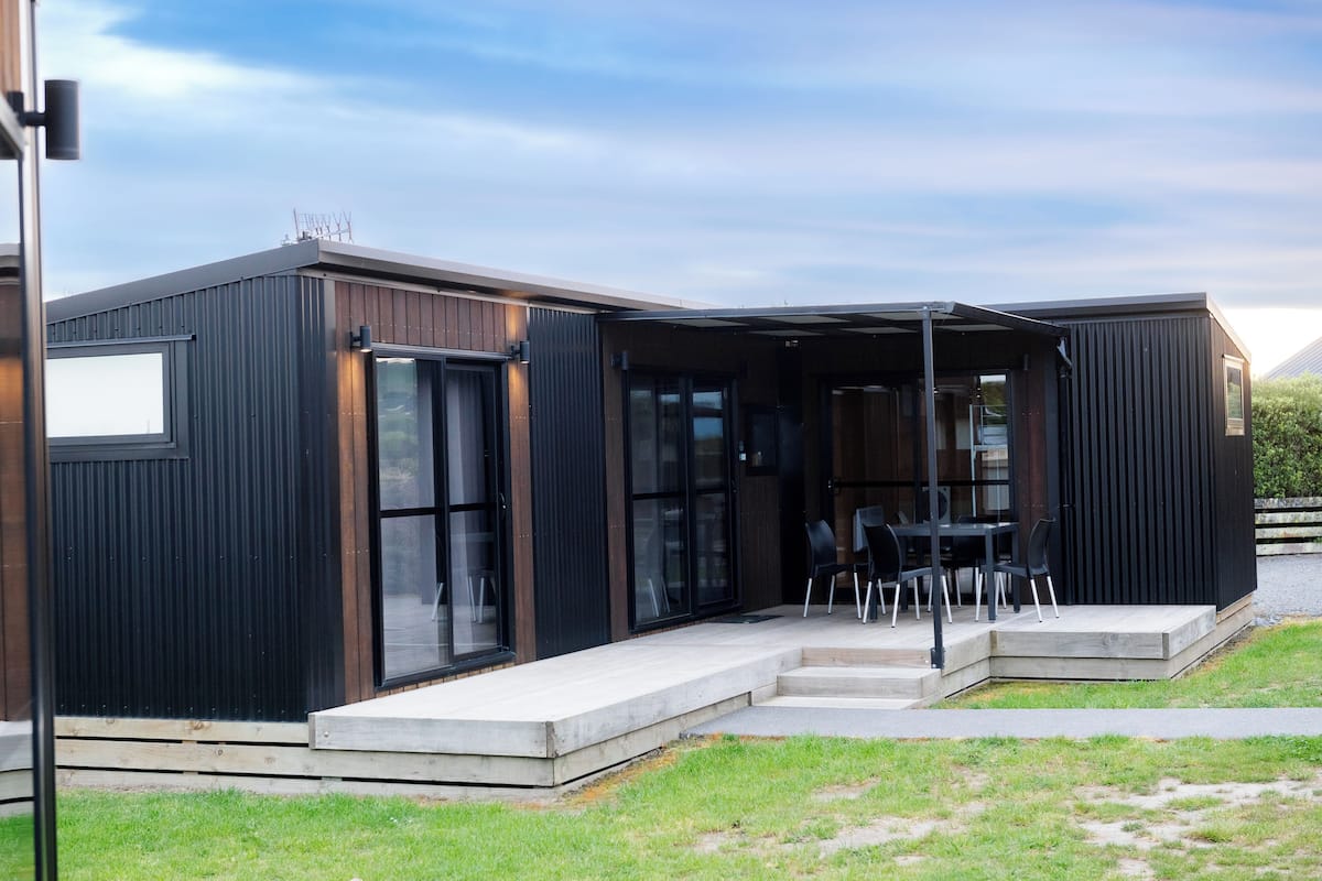 Een modern gebouw met een overdekt terras en grote ramen.