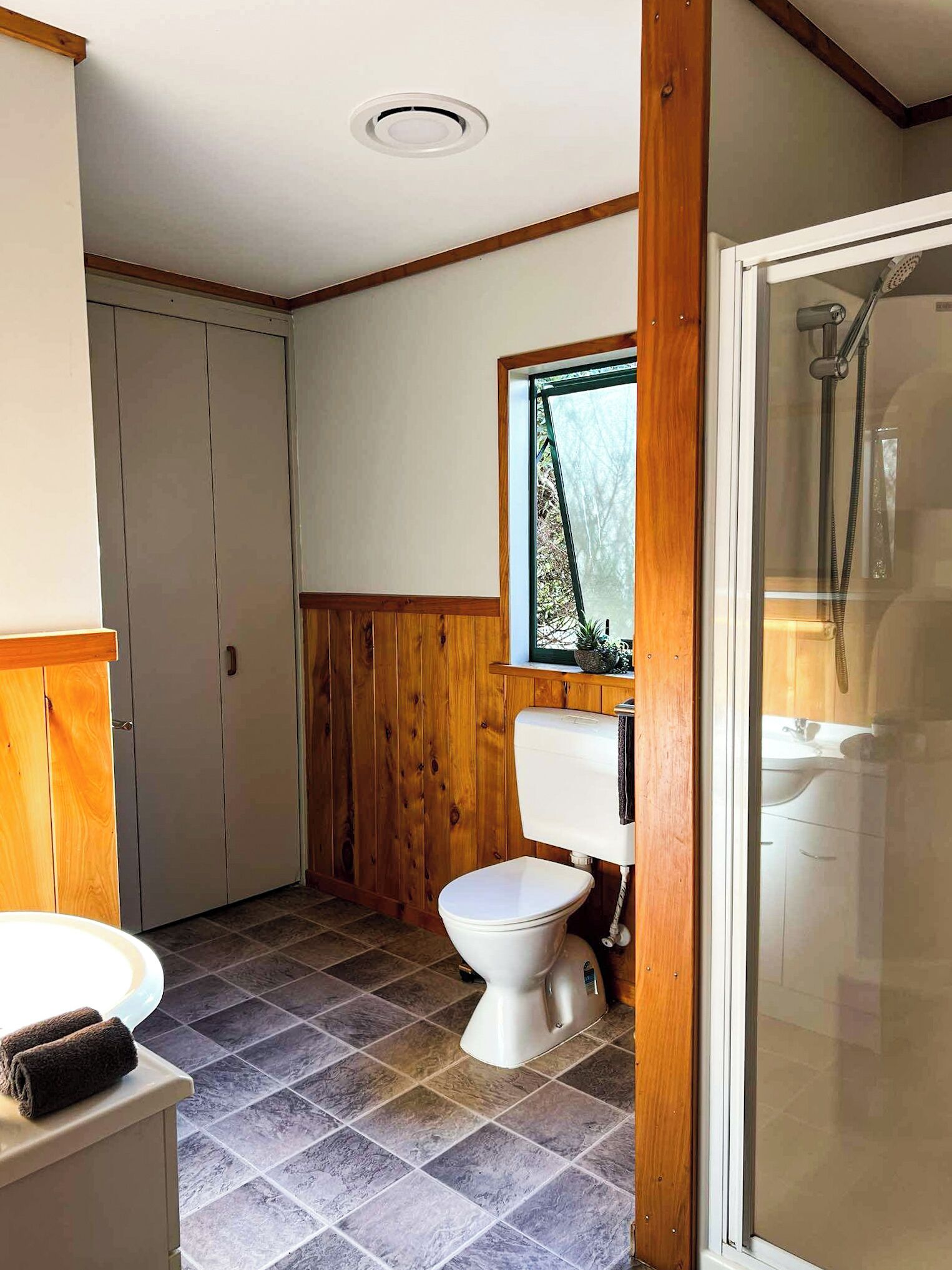 A bathroom with a toilet, sink, and shower.