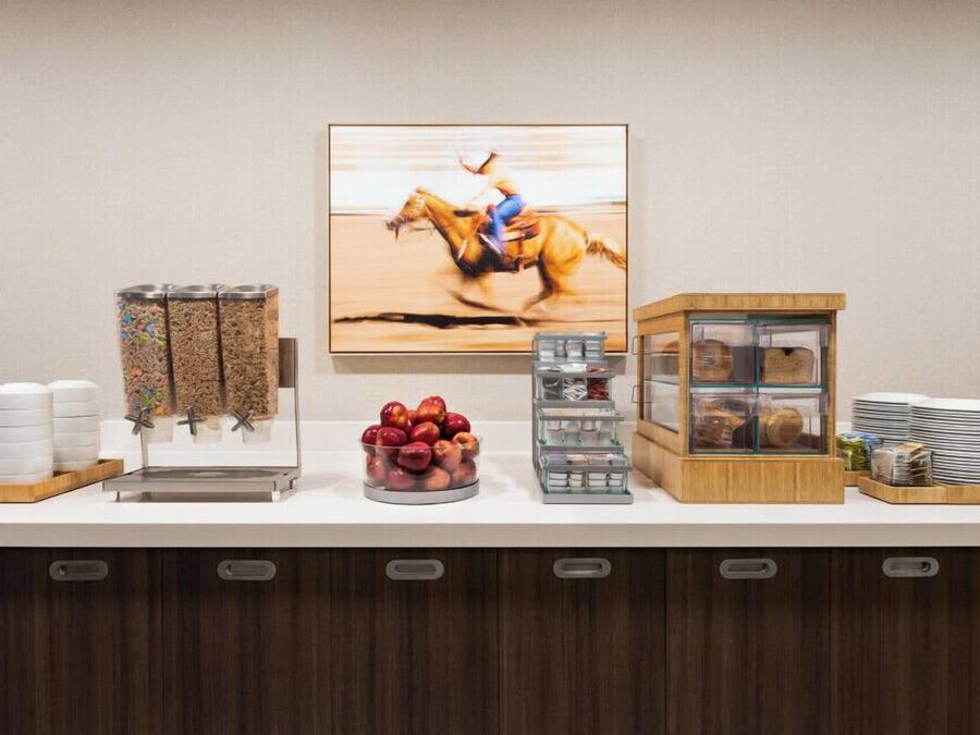 Un buffet proposant divers plats, un coin café et un tableau encadré accroché au mur.