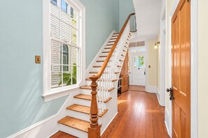 A staircase with wooden steps and white railings leading to a door.