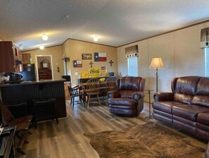 Relax in this stylish living area with a leather sofa, dining area, and bar counter.