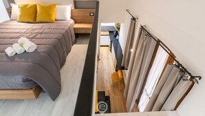 A modern hotel room with a bed, a desk, and a bathroom. - Modern Gem in Castello (Cagliari)