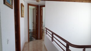 A corridor with a wooden ceiling, white walls, and a tiled floor. - Villa beach (VC)