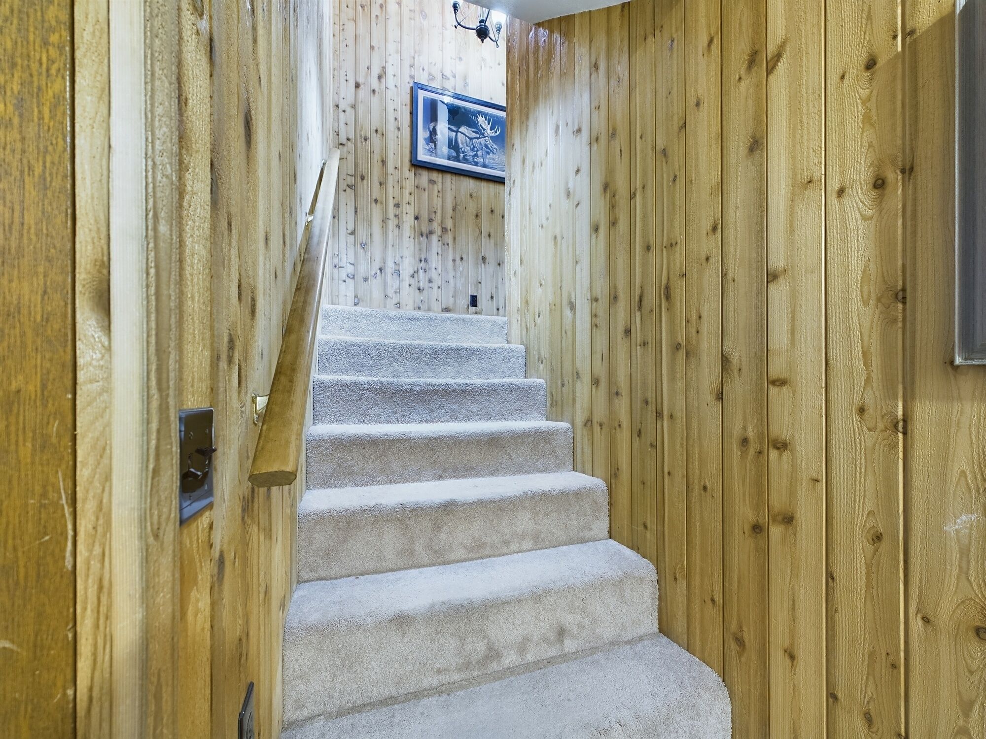 Ein Holzinnenraum mit Teppichstufen, die zu einem gerahmten Bild an der Wand führen.