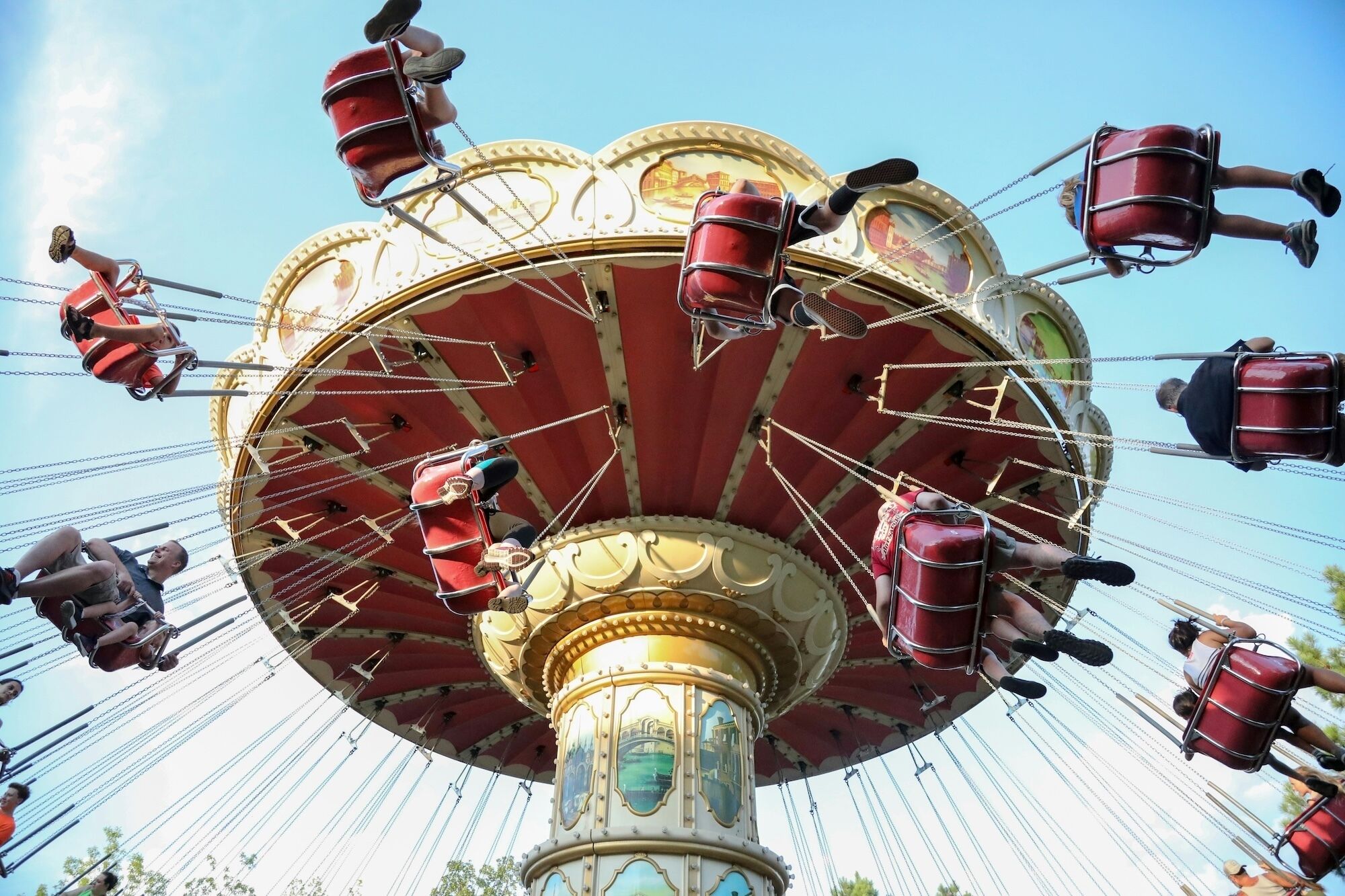 Un carrousel doté de plusieurs sièges et d’un pilier central.