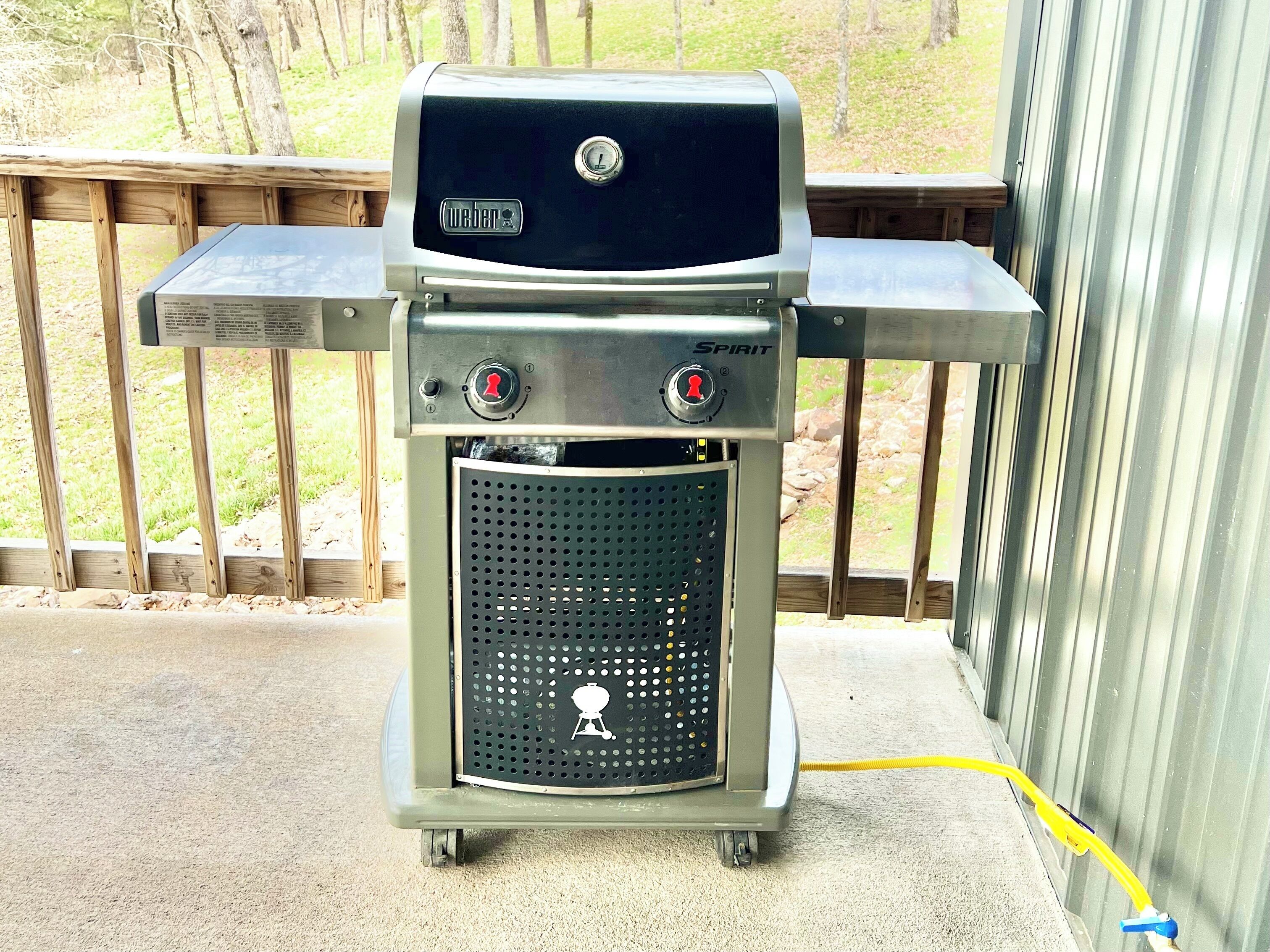 A portable Spirit grill with a digital display, two control knobs, and a ventilation grill.