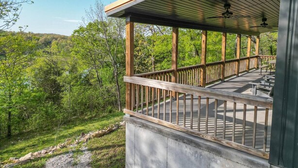 A wooden deck with a railing, overlooking a forested area. - Lakefront Retreat w/Views, Fire Pit & 2 Acres (Golden)