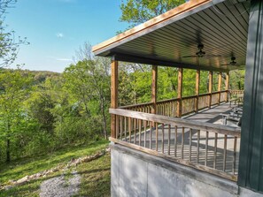 A wooden deck with a railing, overlooking a forested area. - Lakefront Retreat w/Views, Fire Pit & 2 Acres (Golden)