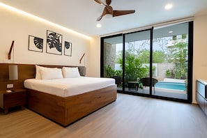 A modern bedroom with a wooden bed, a ceiling fan, and a large sliding glass door leading to a pool area.