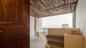 A modern interior with a wooden door, a staircase, and a seating area with a table and chairs. - Moots Tulum (Tulum)
