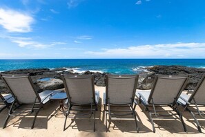 Relax in comfort with four lounge chairs facing the ocean.