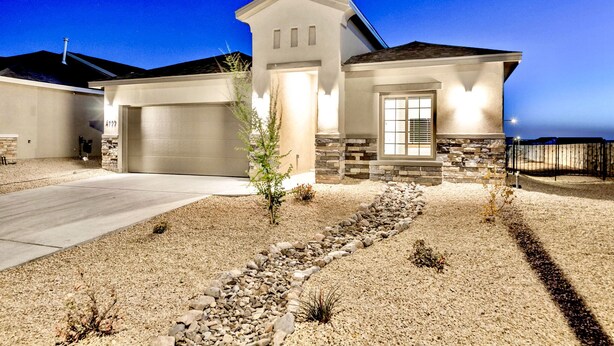 A modern two-story house with a stone facade, a garage, and a landscaped driveway. - Modern Accessorized 3-Bedroom (Las Cruces)
