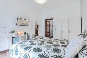 1 dormitorio y tabla de planchar con plancha