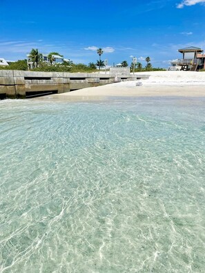 Une plage dégagée, avec un rivage sablonneux et une barrière en béton.