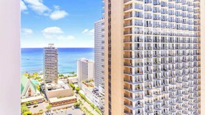 Ein hoch aufragendes Hotel mit modernem Design, das zahlreiche Balkone und einen Blick auf den Ozean bietet.
