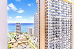 Hotel moderno com muitos andares, design contemporâneo, varandas e vista para o oceano.