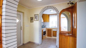 Une cuisine avec des meubles en bois, un pare-feu en carrelage et une fenêtre avec des rideaux.
