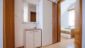 Une chambre à coucher avec une armoire en bois, une table de chevet et un lit.
