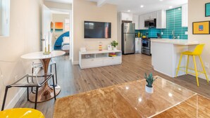 A modern kitchen with a central island, stainless steel appliances, and a teal backsplash. - Pet-Friendly Ocean Beach Villa w/ Fire Pit, Patios & Walk to Beach (San Diego)