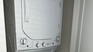 Una lavadora y secadora compacta, de color blanco, con múltiples perillas y ajustes para distintos ciclos y temperaturas de lavado.