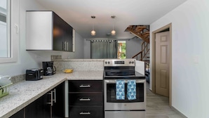 A compact kitchen with a built-in oven, a coffee maker, and a toaster.