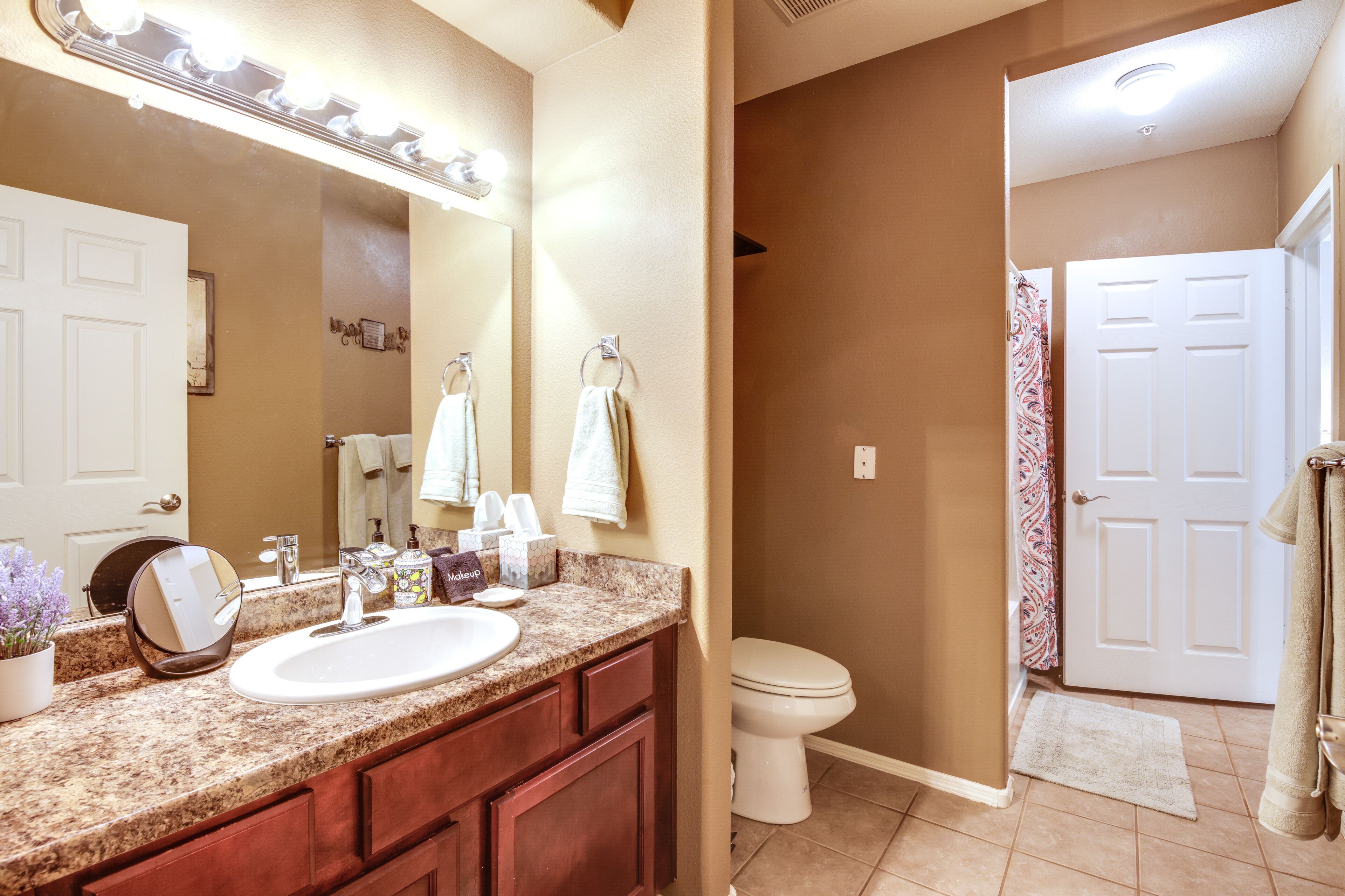 A bathroom with a sink, mirror, and toilet.