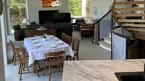 Una cocina moderna con encimera de mármol y comedor con mesa dispuesta para seis personas.