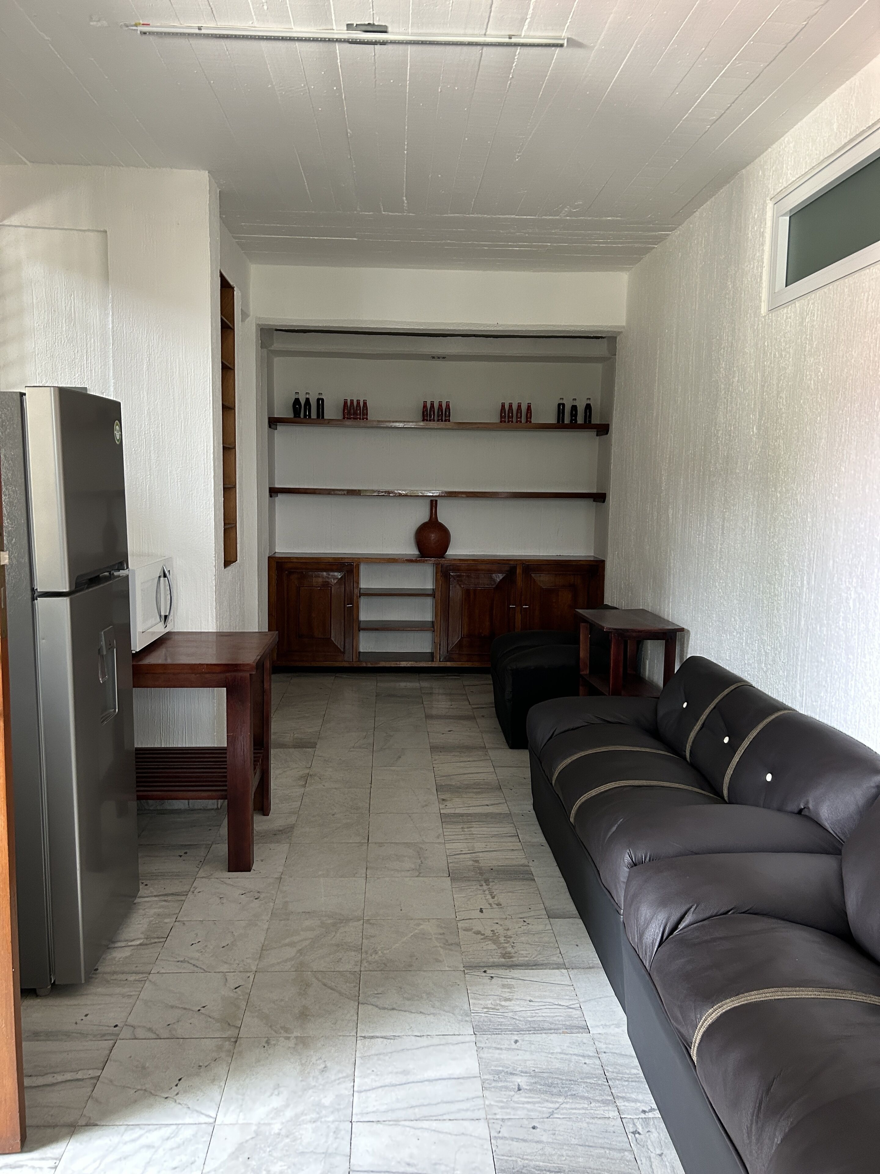 A compact living space with a kitchenette, a sofa, and a dining table.