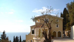 A two-story building with a balcony, arched windows, and a view of the sea. - Villa Alibertini With sea View (Corfu)