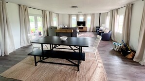 A spacious living area with a dining table, sofas, and a TV. - Townside@LavaHotSprings (Lava Hot Springs)