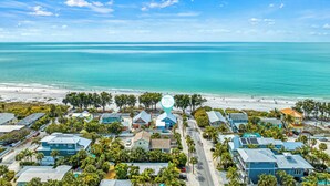Un quartier résidentiel situé sur la côte, avec des maisons, une plage et une vue dégagée sur l’océan.