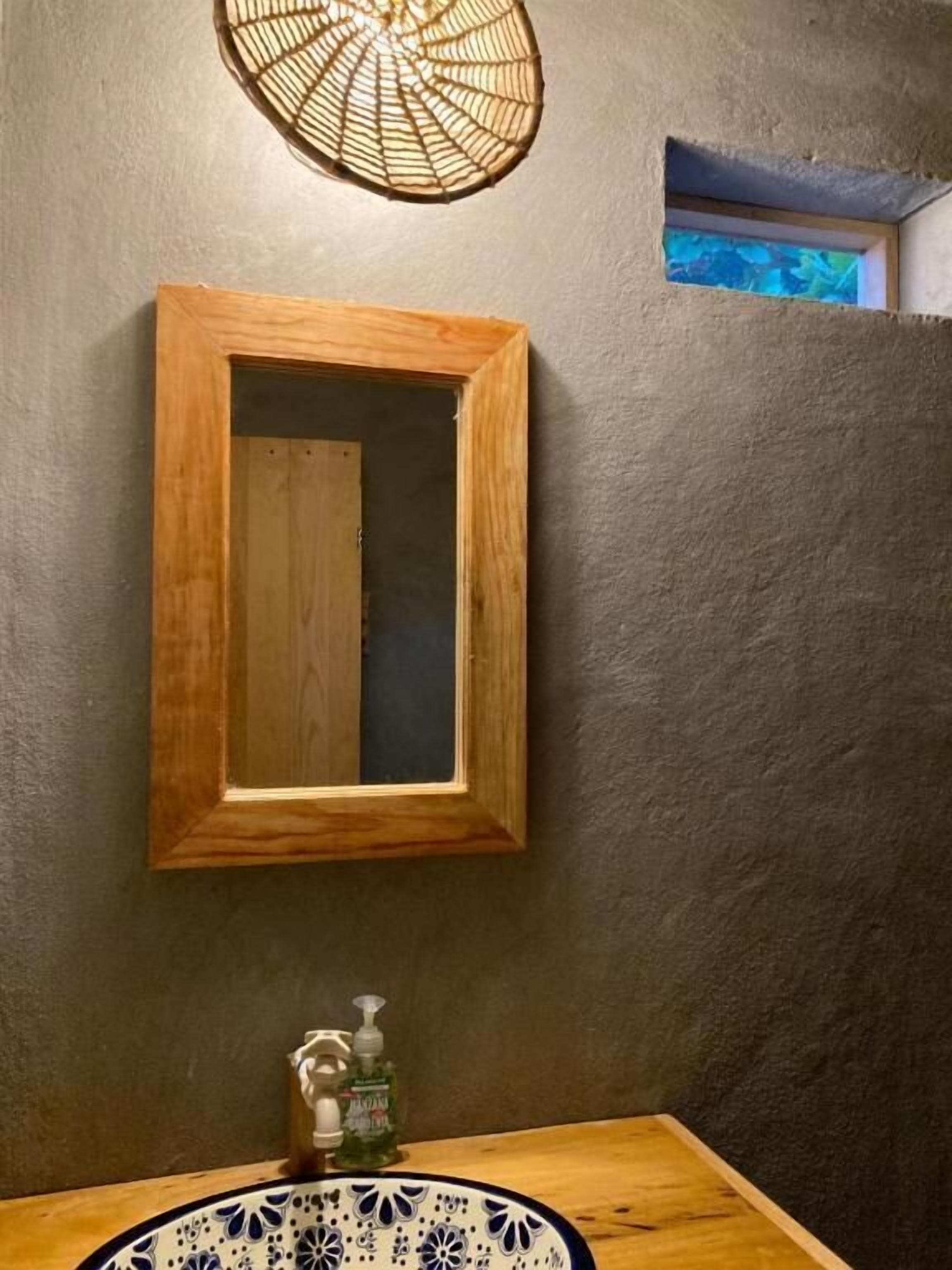 Un bagno con lavandino in legno, uno specchio e un lampadario.