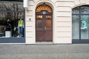Welcome to a charming building with a historic entrance featuring a double door and a retail store to the left.