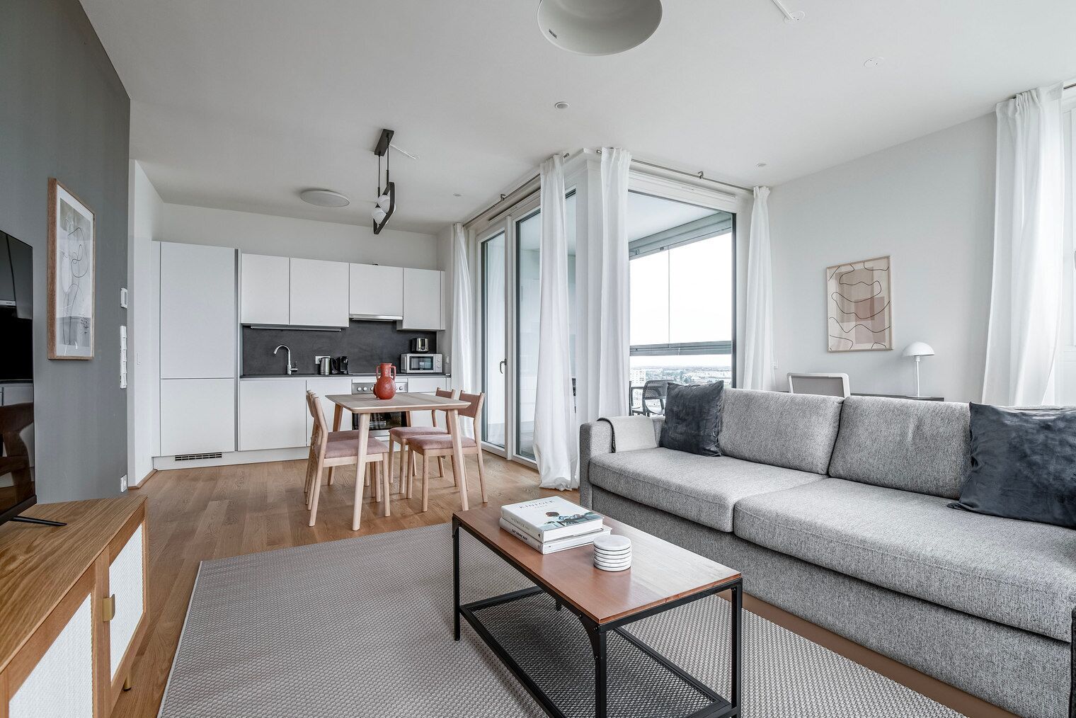 A modern apartment with a dining area, kitchen, and living room.